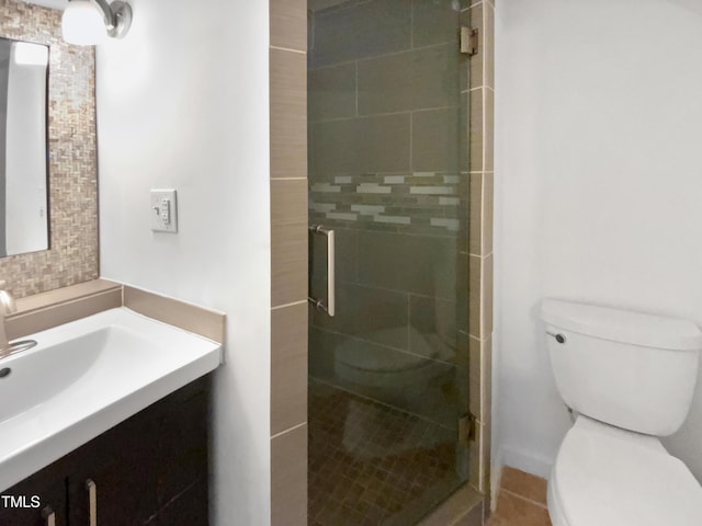 bathroom featuring vanity, an enclosed shower, and toilet