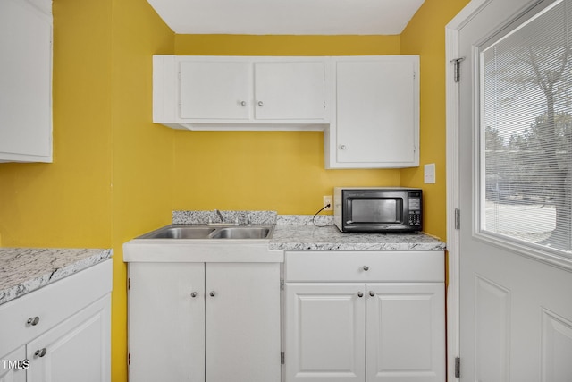 kitchen featuring white cabinetry and sink