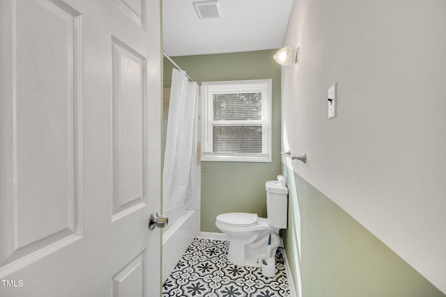 bathroom featuring shower / bath combination with curtain, tile patterned floors, and toilet