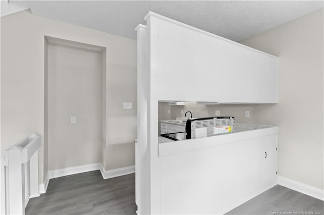 kitchen featuring white cabinetry, sink, and dark wood-type flooring