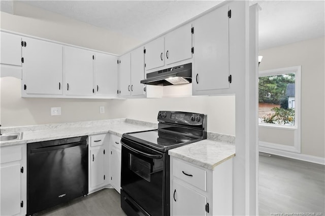 kitchen featuring sink, black appliances, white cabinets, and light wood-type flooring