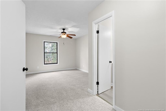 carpeted spare room featuring ceiling fan