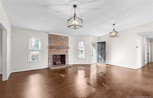 unfurnished living room featuring dark hardwood / wood-style flooring and a brick fireplace