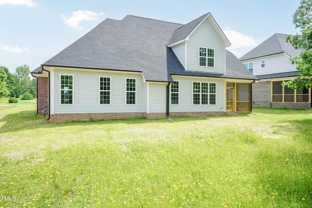 back of property featuring a lawn and a sunroom