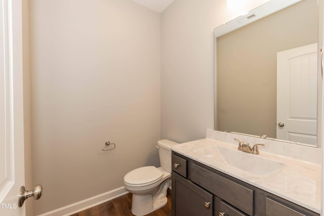 bathroom featuring vanity, hardwood / wood-style floors, and toilet