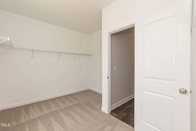 spacious closet with dark colored carpet