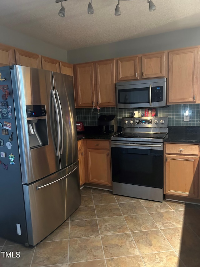 kitchen featuring backsplash, stainless steel appliances, and a textured ceiling