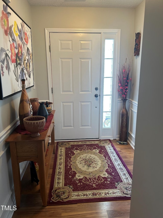 entrance foyer with wood-type flooring and a textured ceiling