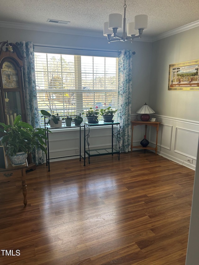 interior space featuring crown molding, plenty of natural light, dark wood-type flooring, and a chandelier