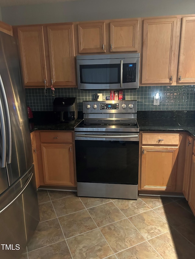 kitchen featuring tasteful backsplash, stainless steel appliances, and dark stone countertops