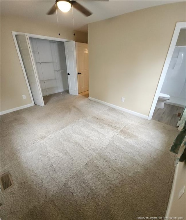 unfurnished bedroom with carpet floors, connected bathroom, ceiling fan, and a closet