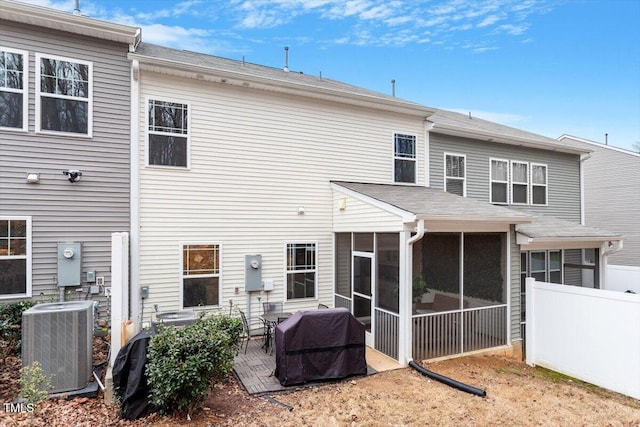 rear view of house featuring a patio, a sunroom, and central AC