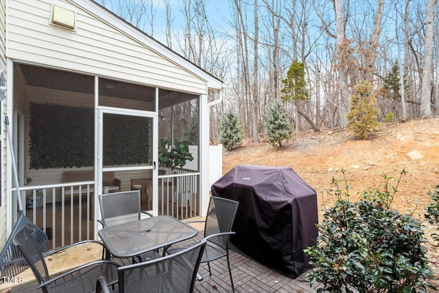 wooden terrace featuring grilling area and a sunroom