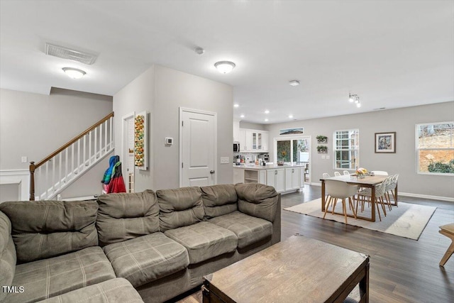 living room with dark hardwood / wood-style flooring and a wealth of natural light