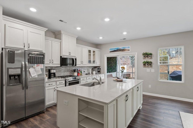 kitchen featuring sink, stainless steel appliances, an island with sink, and white cabinets