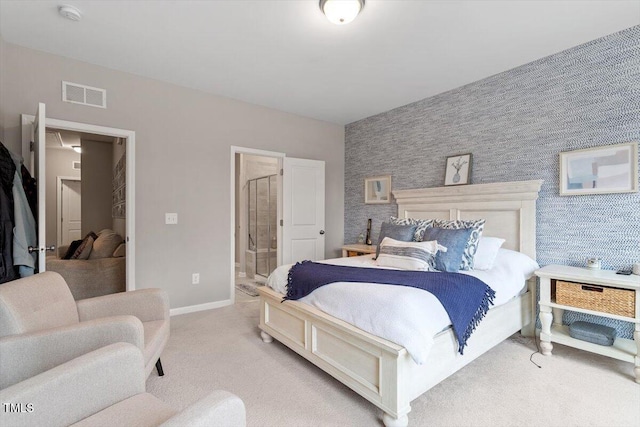 bedroom featuring light carpet and ensuite bathroom