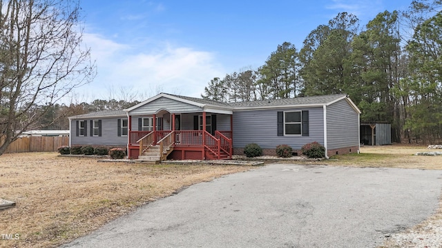 manufactured / mobile home featuring a storage unit and a porch