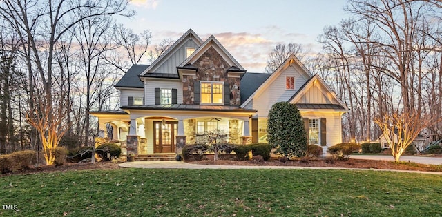 craftsman house with a porch, metal roof, a standing seam roof, a front lawn, and board and batten siding