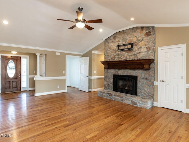 unfurnished living room with crown molding, a stone fireplace, and light hardwood / wood-style floors