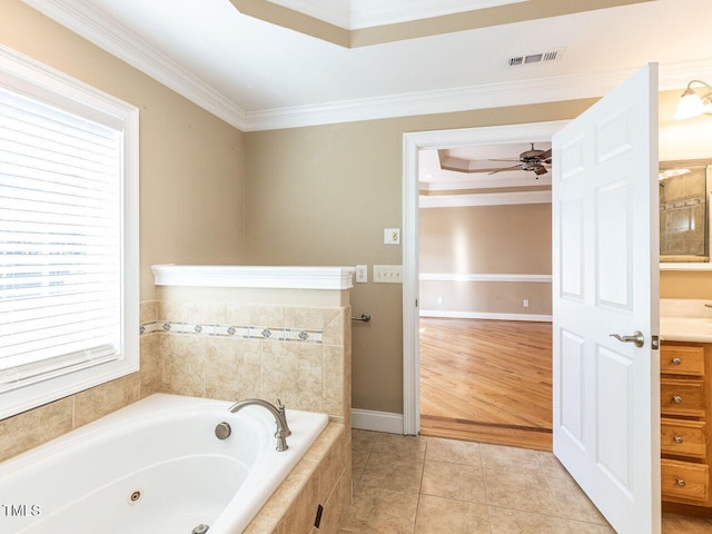 bathroom featuring vanity, ceiling fan, tiled tub, crown molding, and tile patterned floors