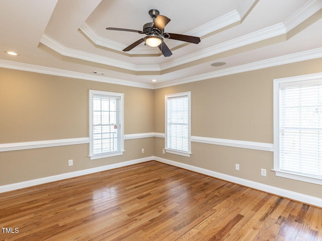 unfurnished room featuring crown molding, a tray ceiling, ceiling fan, and light wood-type flooring