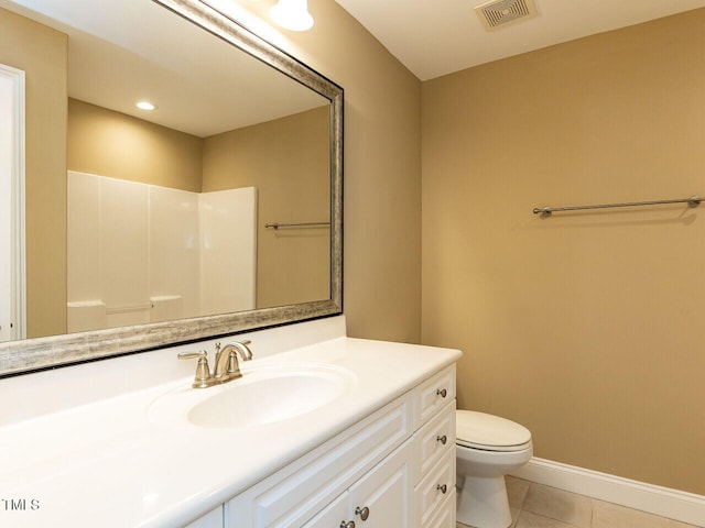 bathroom with tile patterned flooring, vanity, toilet, and walk in shower