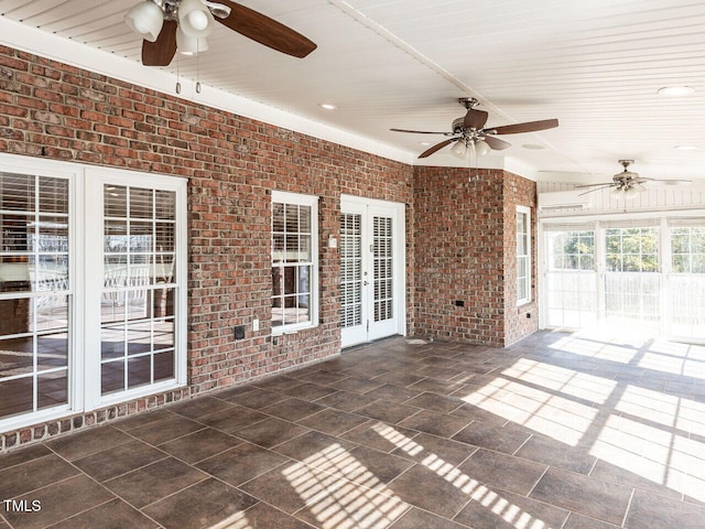 unfurnished sunroom featuring ceiling fan