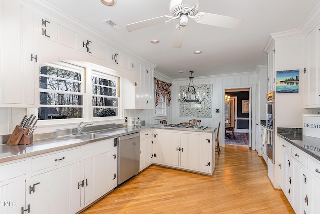 kitchen with pendant lighting, appliances with stainless steel finishes, crown molding, and white cabinets