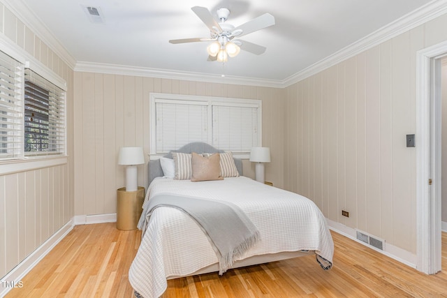 bedroom with crown molding, ceiling fan, and light hardwood / wood-style floors