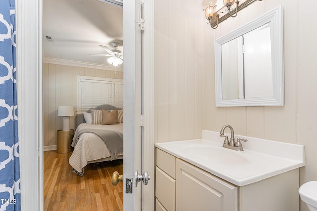 bathroom featuring crown molding, ceiling fan, hardwood / wood-style floors, vanity, and toilet