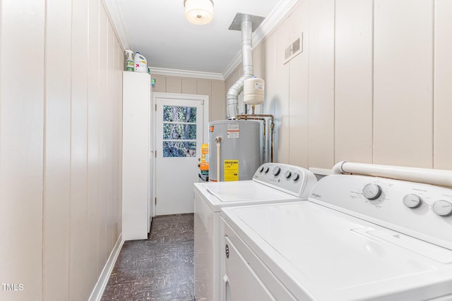 clothes washing area featuring crown molding, washing machine and dryer, water heater, and wood walls