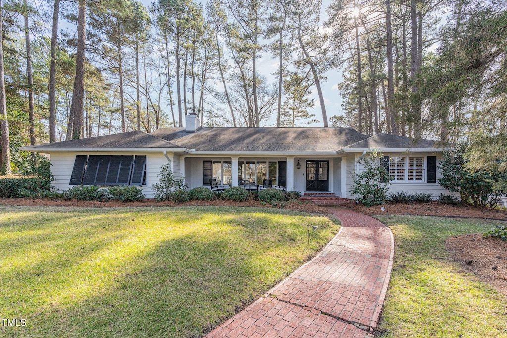 ranch-style home with a front yard and a porch