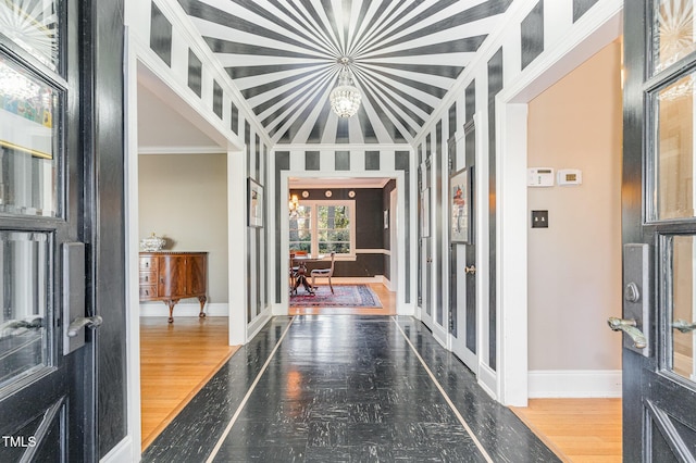 interior space with crown molding, hardwood / wood-style flooring, and vaulted ceiling