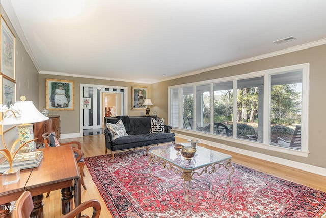 living room featuring crown molding, wood-type flooring, and a healthy amount of sunlight