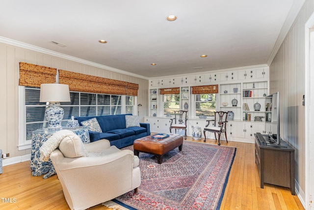 living room with ornamental molding and light hardwood / wood-style flooring