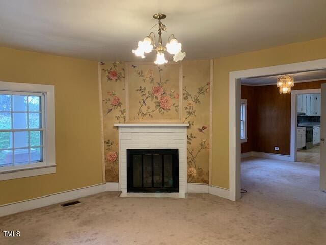 unfurnished living room with a fireplace, a chandelier, and light carpet