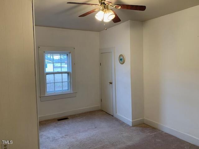 empty room with light colored carpet and ceiling fan