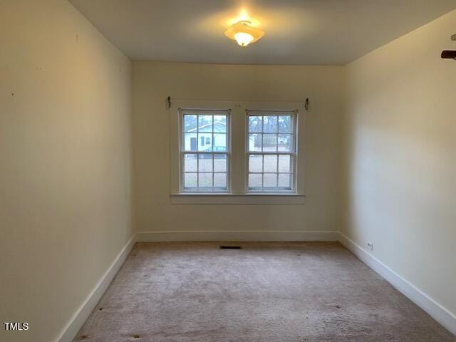 spare room featuring light colored carpet