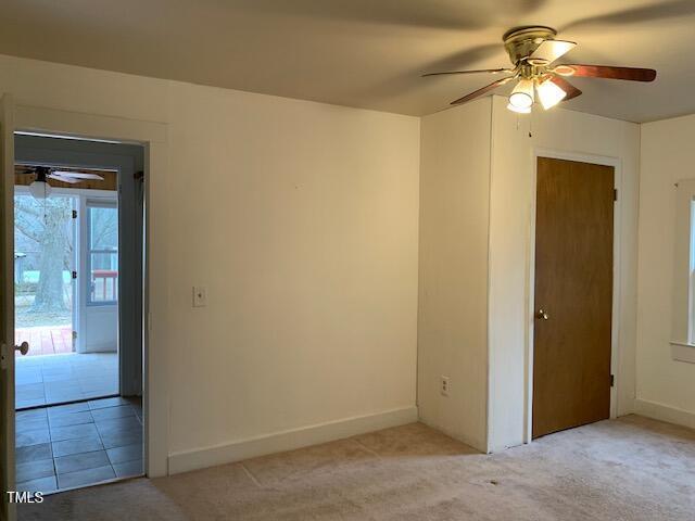 carpeted empty room featuring ceiling fan