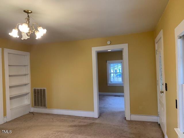 unfurnished room featuring an inviting chandelier and light colored carpet