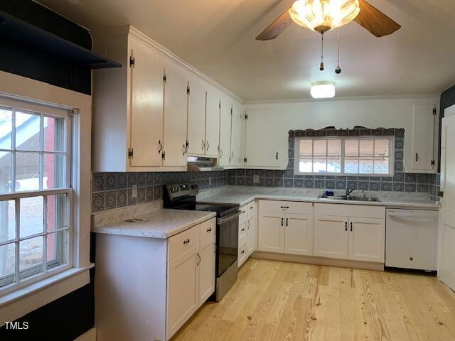 kitchen with white dishwasher, sink, stainless steel electric stove, and white cabinets