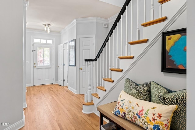 entrance foyer with ornamental molding and hardwood / wood-style floors