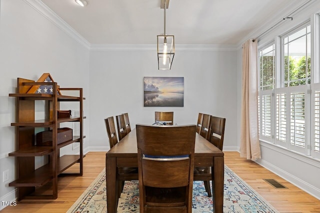 dining area featuring ornamental molding and light wood-type flooring