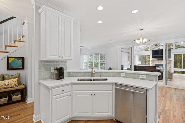 kitchen with sink, light hardwood / wood-style flooring, white cabinetry, tasteful backsplash, and stainless steel dishwasher