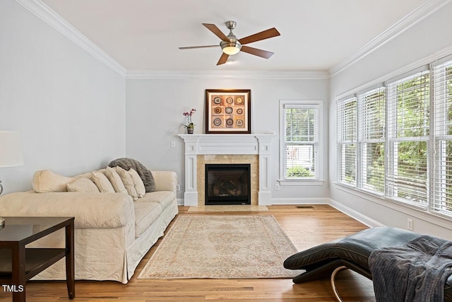 living room with crown molding, ceiling fan, and light hardwood / wood-style floors