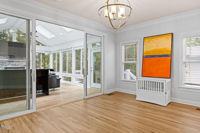 doorway to outside with an inviting chandelier, crown molding, light hardwood / wood-style flooring, and lofted ceiling with skylight