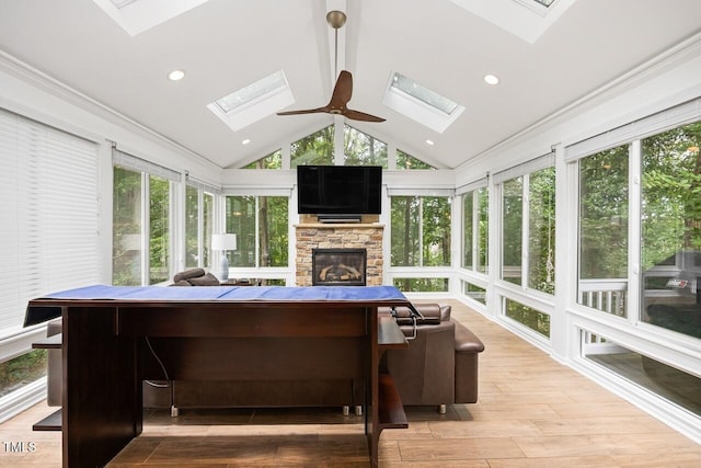 sunroom / solarium featuring ceiling fan, lofted ceiling, and a fireplace