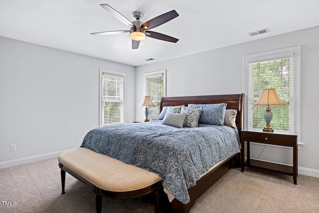 carpeted bedroom with multiple windows and ceiling fan