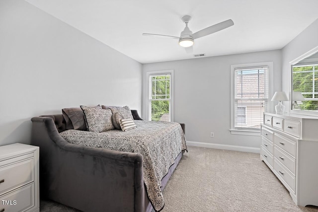 bedroom featuring ceiling fan, light colored carpet, vaulted ceiling, and multiple windows