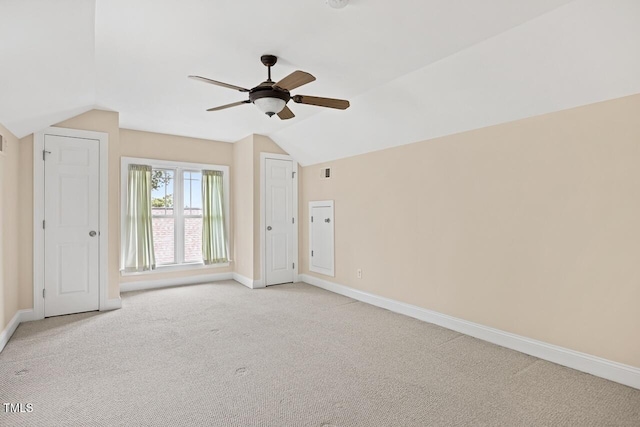 carpeted spare room featuring ceiling fan and vaulted ceiling